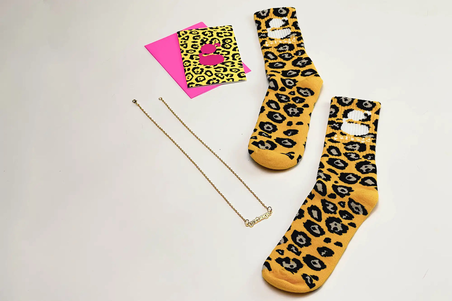 Yellow leopard-print socks with black and gray spots, featuring distressed white patches on the top.