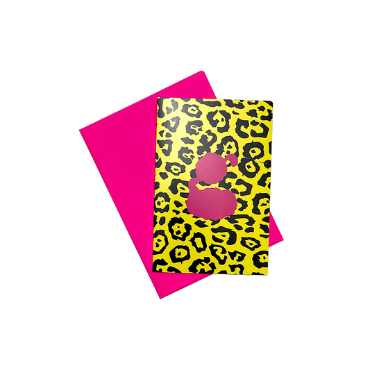 Greeting card with leopard print design and pink silhouette on yellow background, paired with solid pink envelope.